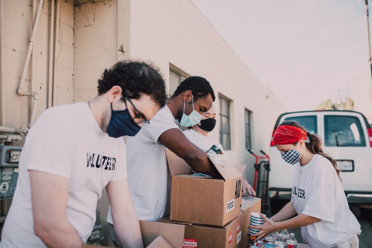 Volunteers packing food donations outdoors to support a local charity event.