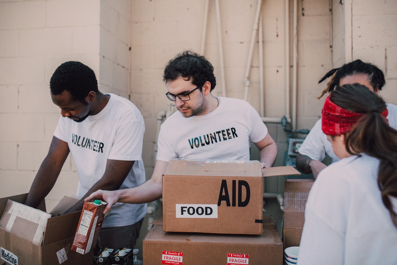 Group of volunteers packing food and aid boxes during a charity drive.